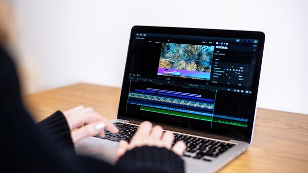 Chica joven creadora de contenido editando video en su computadora portátil. Trabajando desde casa