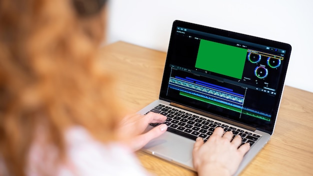 Chica joven creadora de contenido editando video en su computadora portátil. Trabajando desde casa