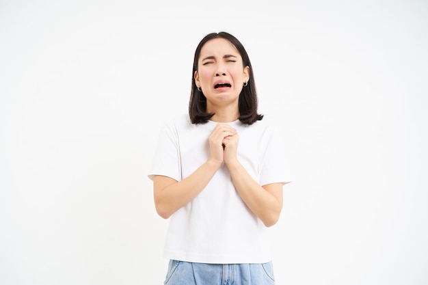 Foto gratuita chica joven desesperada llorando y suplicando pidiendo ayuda pidiendo algo de fondo blanco