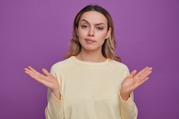 Chica joven despistada mostrando las manos vacías