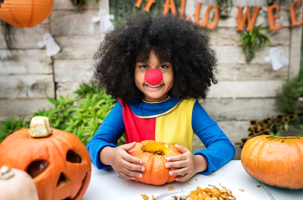 Chica joven disfruta tallando su calabaza de Halloween