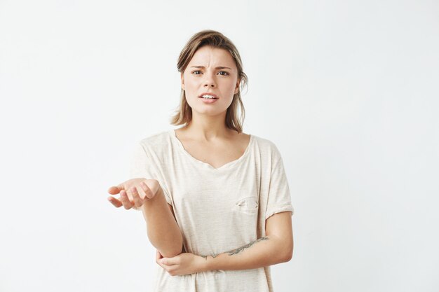 Chica joven disgustada gesticular hablando.