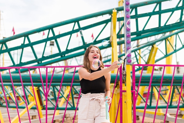 Chica joven divirtiéndose en el parque de atracciones