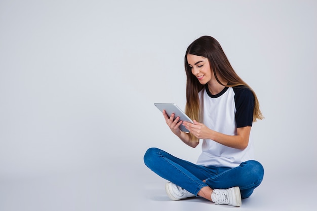 Foto gratuita chica joven divirtiéndose con la tablet