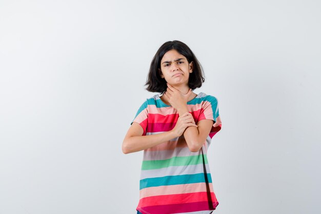 Chica joven con dolor de cuello en camiseta a rayas de colores y mirando exhausto, vista frontal.