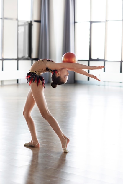 Foto gratuita chica joven entrenando en gimnasia