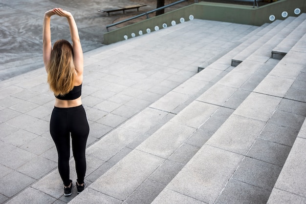 Chica joven estirando en la calle