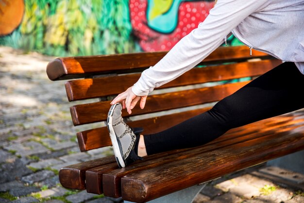 Chica joven estirando en la calle