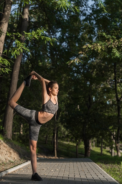 Foto gratuita chica joven estirando en el parque