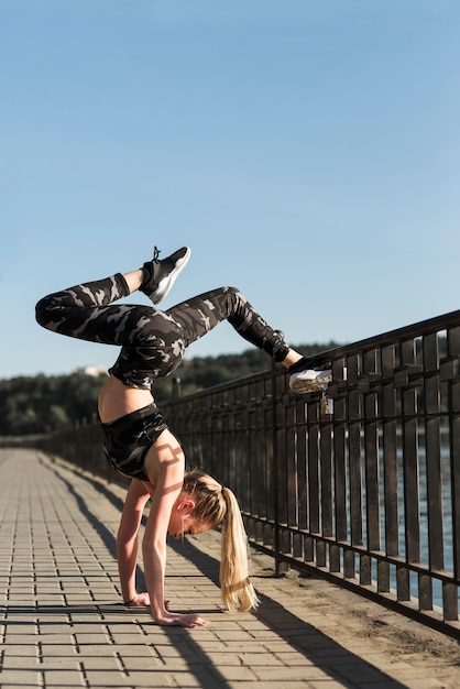 Chica joven estirando en el parque