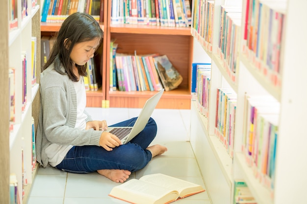 Chica joven estudiante sentada en una biblioteca