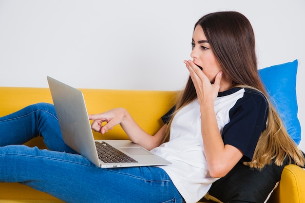 Chica joven estupefacta con su portátil