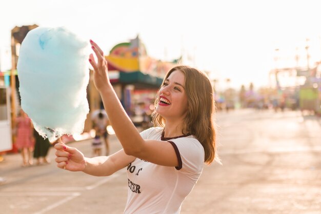 Chica joven feliz en el parque de atracciones