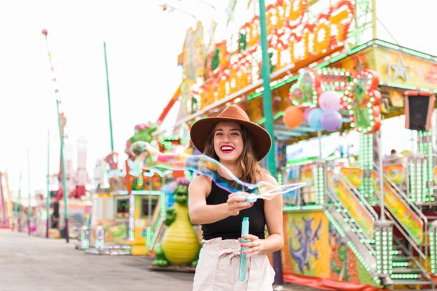 Chica joven feliz en el parque de atracciones
