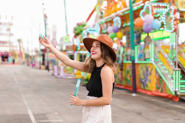 Chica joven feliz en el parque de atracciones