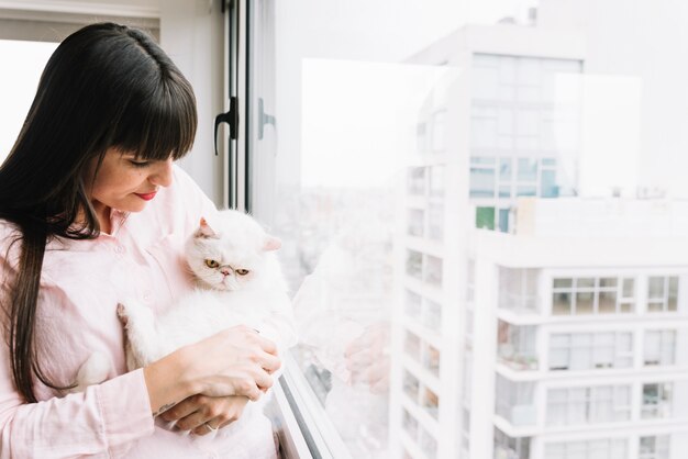 Chica joven feliz posando con su gato