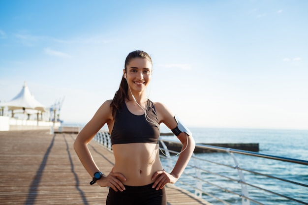 chica joven fitness lista para ejercicios deportivos junto al mar