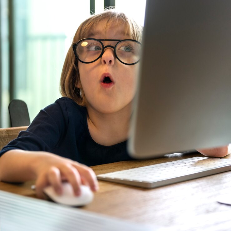 Foto gratuito chica joven con gafas sorprendida por usar una computadora