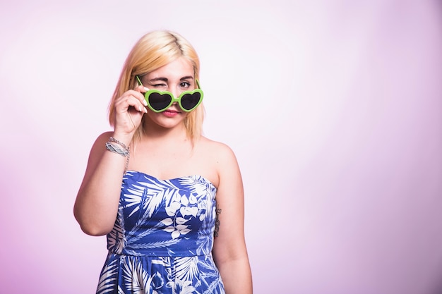 Chica joven guiñando con gafas de sol