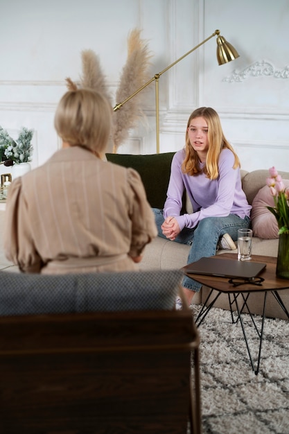 Foto gratuita chica joven hablando con terapeuta tiro completo