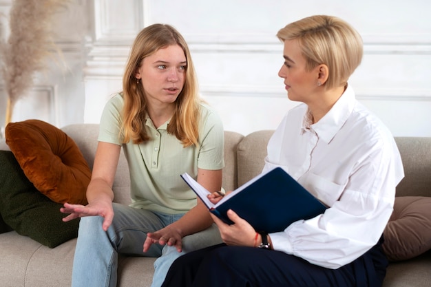 Chica joven hablando con terapeuta de tiro medio