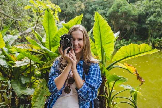 Foto gratuita chica joven haciendo foto en la jungla