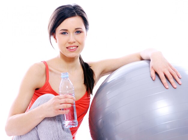 Chica joven y hermosa con una botella de agua mineral.