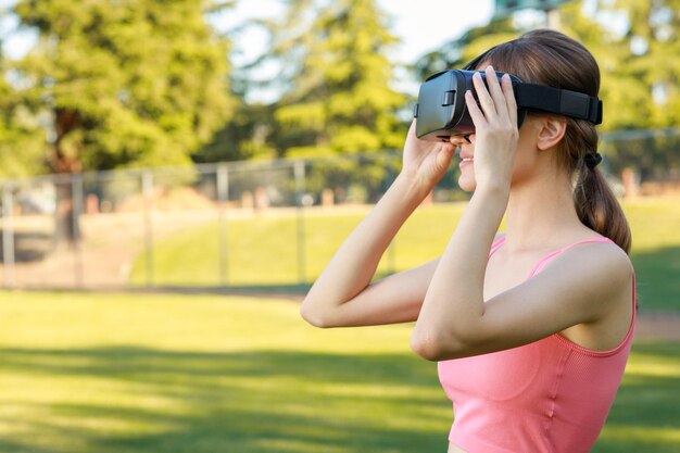 Chica joven con juego de realidad virtual en el parque