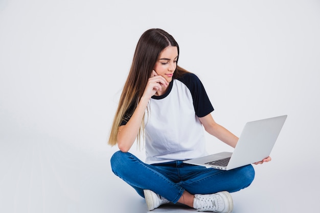 Foto gratuita chica joven leyendo en el portátil