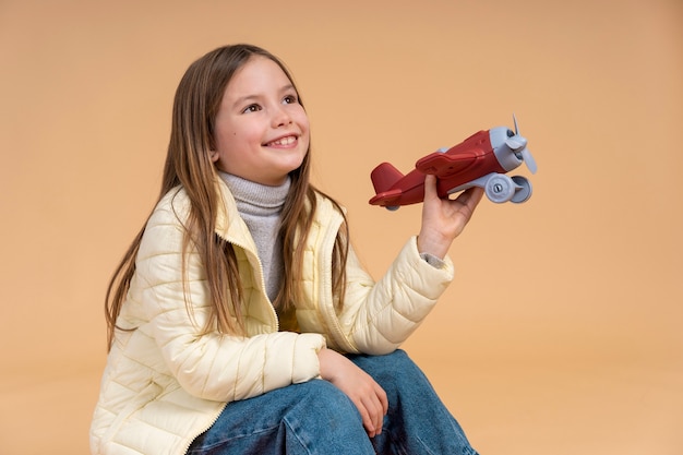 Foto gratuita chica joven lista para viajar de vacaciones con avión de juguete