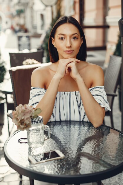 Chica joven de moda en un café de verano