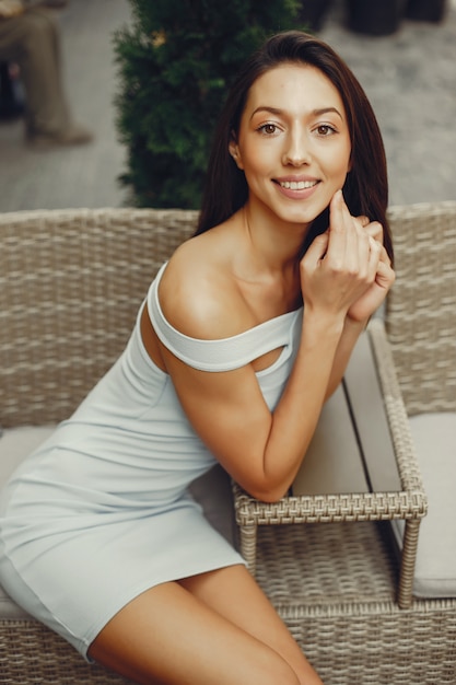 Chica joven de moda en un café de verano