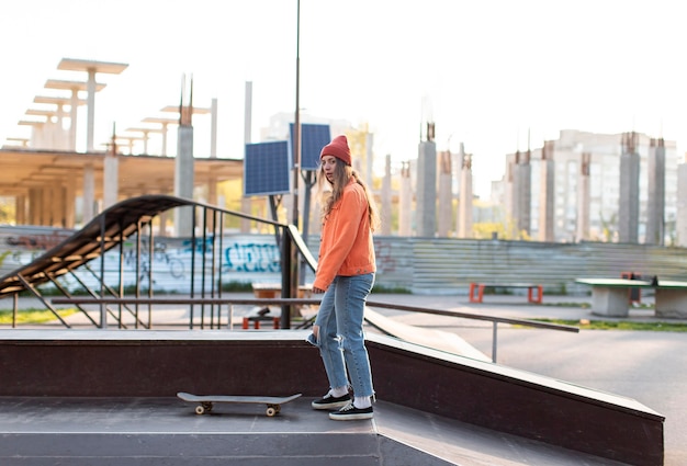 Chica joven con patineta al aire libre full shot