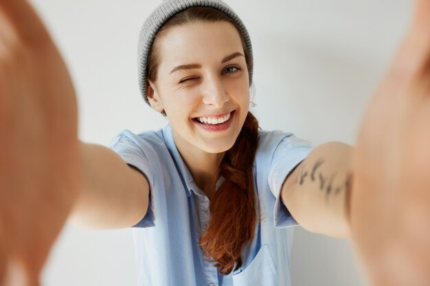 Chica joven pelirroja con sombrero y camisa azul