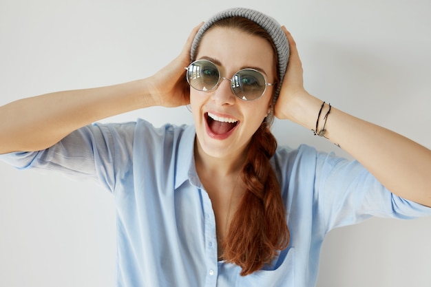 Foto gratuita chica joven pelirroja con sombrero y gafas de sol