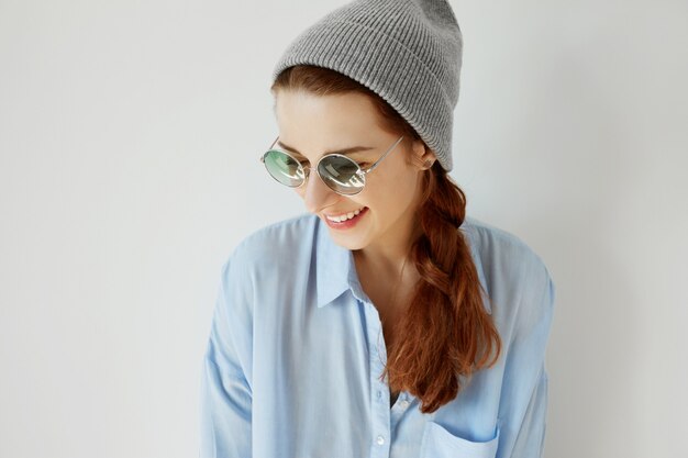 Chica joven pelirroja con sombrero y gafas de sol