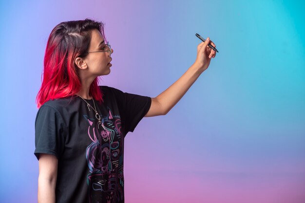 Chica joven con pelos rosados sosteniendo una pluma.