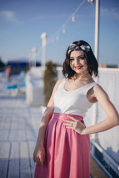 Chica jóven posando en un puerto marítimo