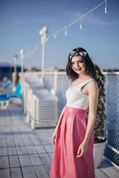 Chica jóven posando en un puerto marítimo