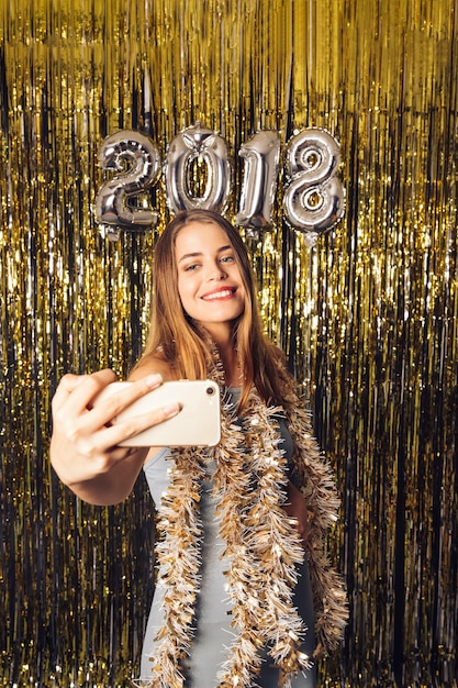 Chica joven posando para un selfie en celebración de año nuevo