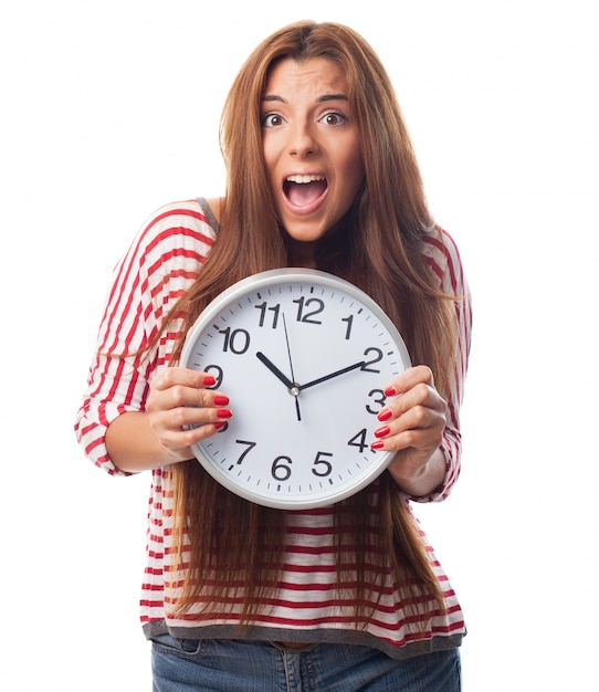 Foto gratuita chica joven que oculta detrás de un reloj.