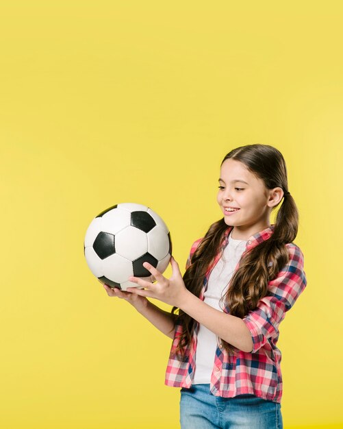 Chica joven que sostiene el balón de fútbol
