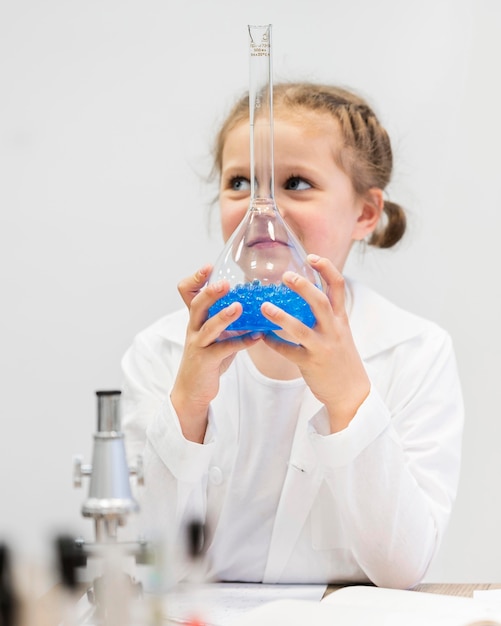 Foto gratuita chica joven que sostiene el tubo de la ciencia