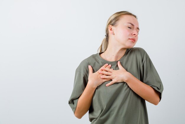 Chica joven que tiene un ataque al corazón sobre fondo blanco.