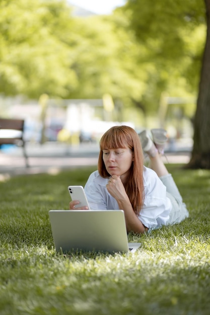 Foto gratuita chica joven que trabaja en una computadora en el parque