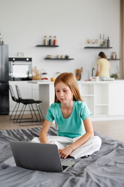 chica joven que usa la computadora portátil en casa