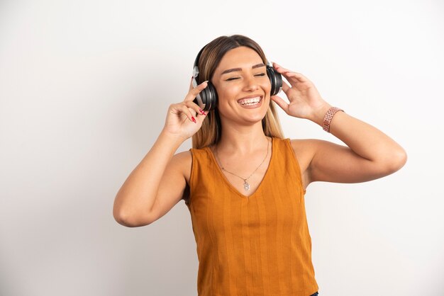 Chica joven en ropa casual posando con auriculares.