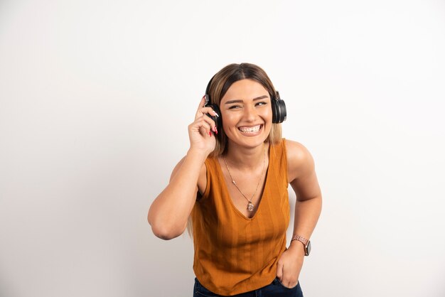 Chica joven en ropa casual posando con auriculares.