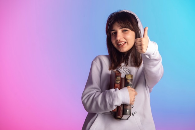 Chica joven en ropa deportiva y peinado corto sosteniendo un libro y disfrutando.