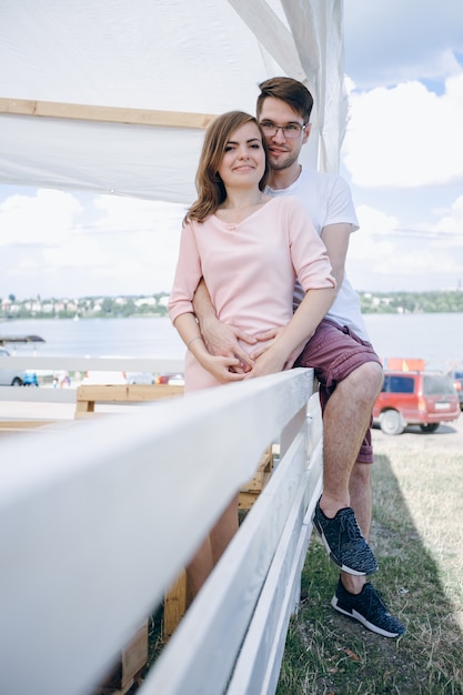 Foto gratuita chica joven sonriendo mientras su novio la abraza